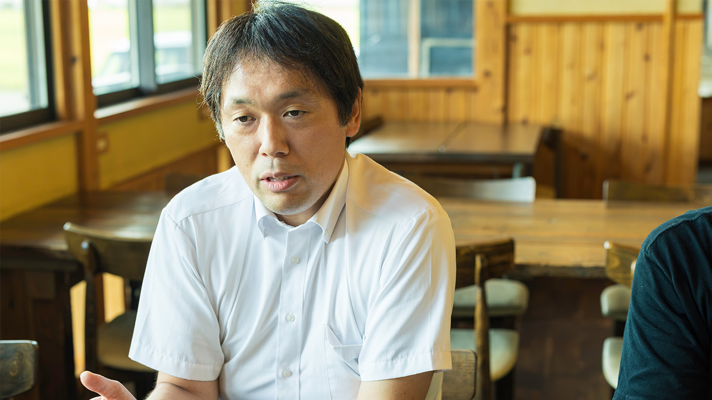 テーブルを挟み取材に答える齋藤光さん